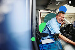 Smiling male sitting in driver's seat of a logistics truck